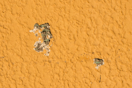 Hole wall close-up ruined broken damaged construction texture bright yellow surface building.