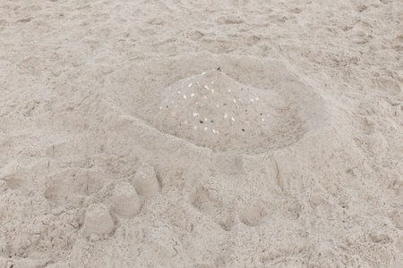 Children's entertainment sand white castle with seashells on the beach.