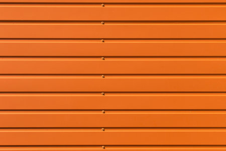 Orange brown galvanized iron metal fence bolts abstract texture background wall steel structure backdrop horizontal.の写真素材