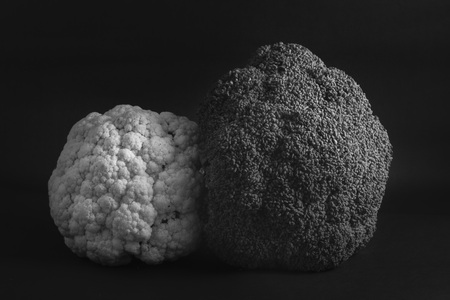 Couple of cauliflower and broccoli on a dark background, with theatrical lighting. Fresh vegetables. Dark cauliflower.の写真素材