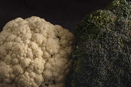 Couple of cauliflower and broccoli on a dark background, with theatrical lighting. Fresh vegetables. Dark cauliflower.の写真素材