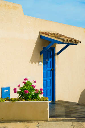 blue front door with pink geranium in Cyprusの写真素材