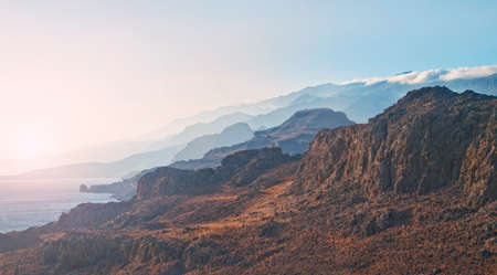 cross-processed panoramic  image of mountain range in warm evening sun in Schinaria, Crete, Greeceの写真素材