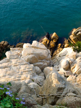 top view of fisherman sitting on rocks with fishing rods in Ulsanの写真素材