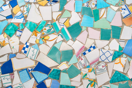 broken pieces of beautiful ceramics tiled in mosaic on street wall in ceramic capital of Italy,...