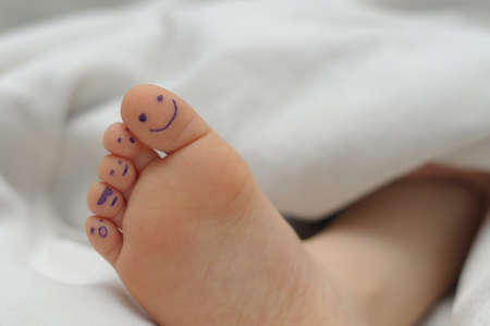 Children  heel on blanket with smiles on fingersの写真素材