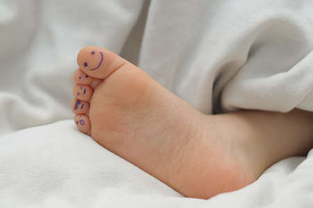 Children  heel on blanket with smiles on fingersの写真素材