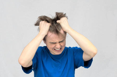 White caucasian man ripping his hair with two hands