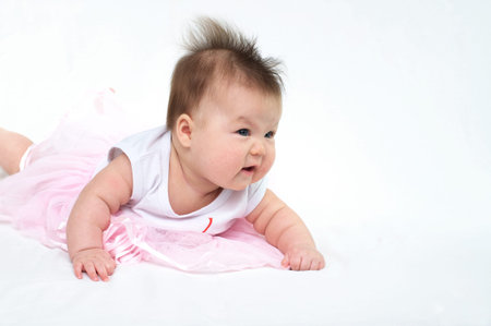 Newborn baby in pink dress s looking away