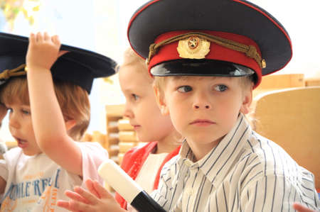 White caucasian European Boy in peaked cap in costume of policeman in kindergartenのeditorial素材