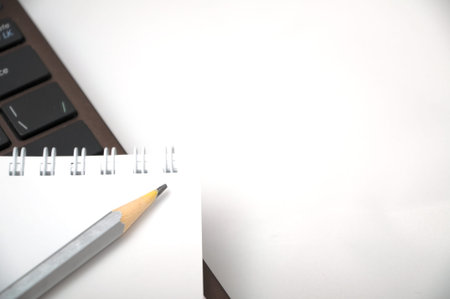 Notebook with pencil on laptop keyboard