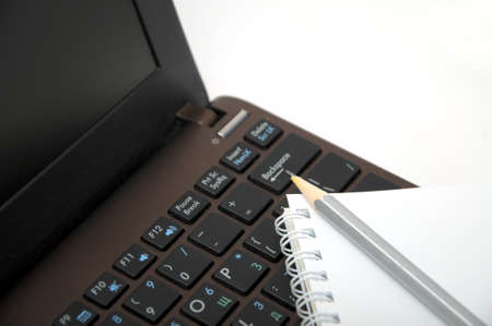 Notebook with pencil on keyboardの写真素材