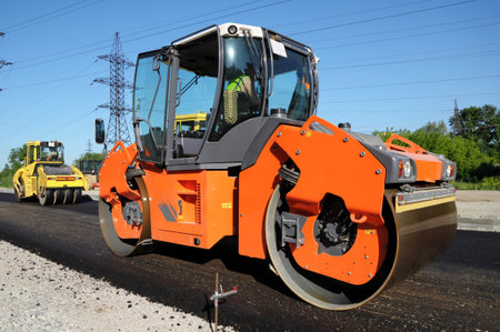 Rolling machinery at work making asphalt. Side view