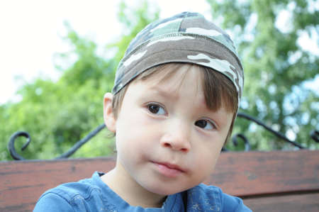Portrait of boy at summertime outdoor on benchの写真素材