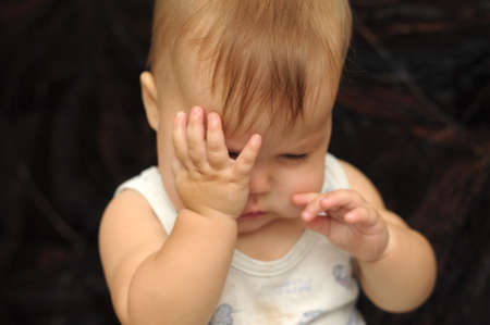 Portrait of nine month baby rubbing his eyesの写真素材