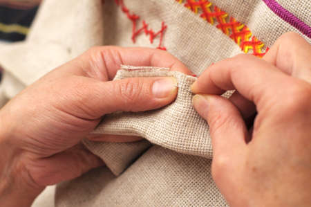 Woman hands sewing with needle and thread close-upの写真素材