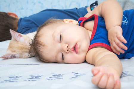 Child baby sleeping daytime with brother and cat