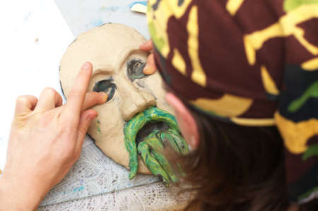 Man sculpting plasticine form of face with moustacheの写真素材