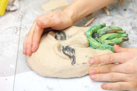 Hands sculpting craft with plasticine the form of face with moustacheの写真素材