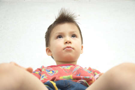 Caucasian boy sitting and watching away, bottom viewの写真素材