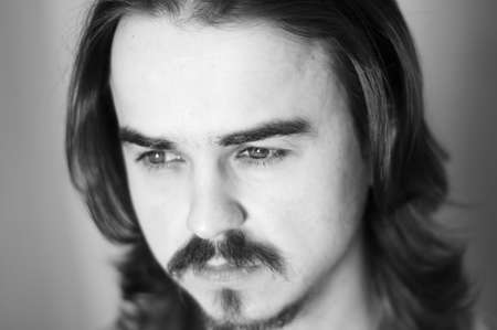 Black-and-white portrait of man with beard and mustaches looking awayの写真素材