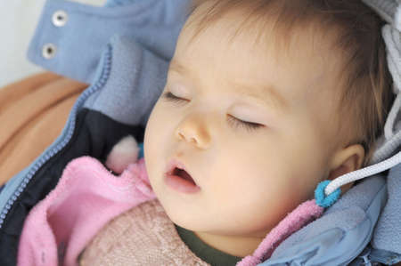 Baby girl sleeping with open mouth daytimeの写真素材