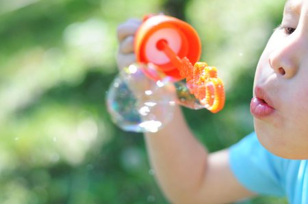 Boy making the soap bubbles at summer outside