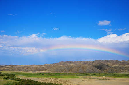 Rainbow in the sky  among hills at summerの写真素材