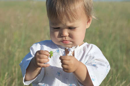 Little girl portrait in the summer field in national russian shirtの写真素材