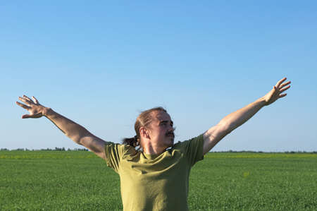 Young man spreading arms and looking rightの写真素材