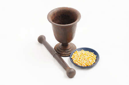 Iron vintage  stamp with pestle  with corn on blue plateの写真素材