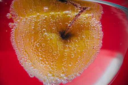 Yellow apple in the bubbles on red backgroundの写真素材