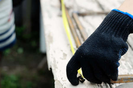 Worker in protective gloves sizing artwork by meterの写真素材