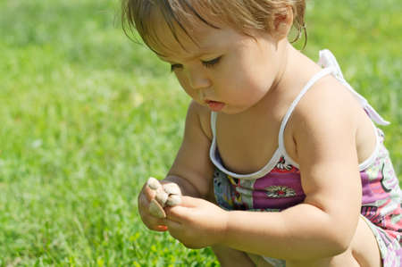 Little girl playing with toxic toadstool mushroomsの写真素材