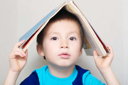 Boy portrait looking forward making book like roofの写真素材