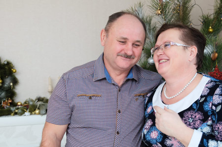 Happy couple middle age, smiling and laughing portrait in Cristmas backgroundの写真素材