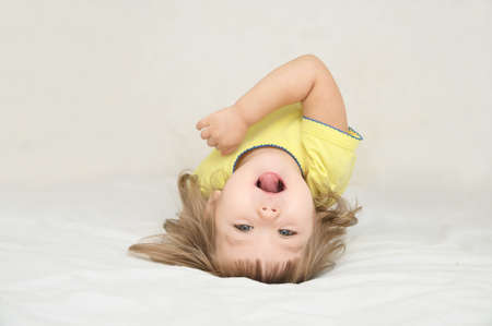 Little girl having fun lying on back spine, backbend, bridge figure, happy smiling child, happiness childhood conceptの写真素材