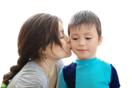Mother kissing son isolated on white background,  trusting relationship concept, boy smiling and happy,child growth, child care by parentの写真素材