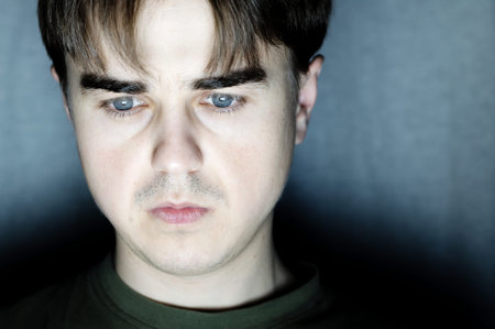 young man portrait in dark room at dark background, young man working at computer, serious...
