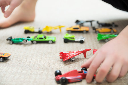 boy playing with car collection on carpet.Child hand play. Transportation, airplane, plane and...