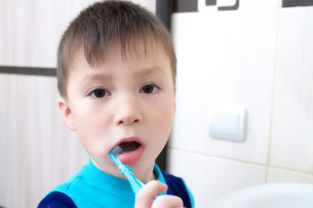 Boy brushing teeth, child dental care, oral hygiene concept, child in bathroom with tooth...