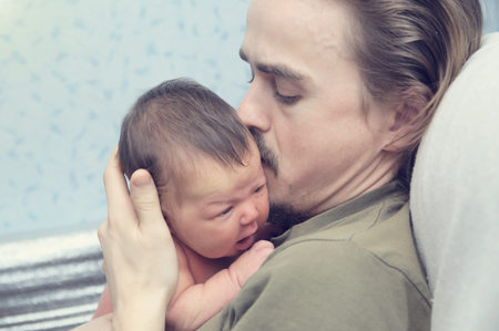 Father holding newborn baby, family loveの写真素材