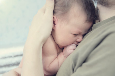 Father holding newborn baby, family love