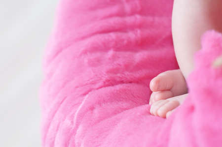 Newborn feet closeup, baby girl heels on pink background of mohair blanket, soft and cuteの写真素材