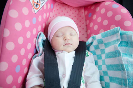 Newborn sleeping in car seat.Safety concept. Infant baby girl. secure driving with children. Baby care lifestyle. Cute baby sleeping in car.の写真素材