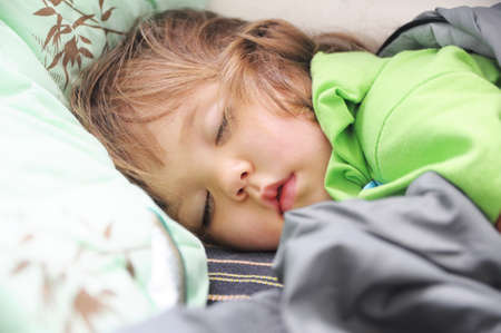 Cute little girl sleeping portrait lying, domestic child day time sleepの写真素材