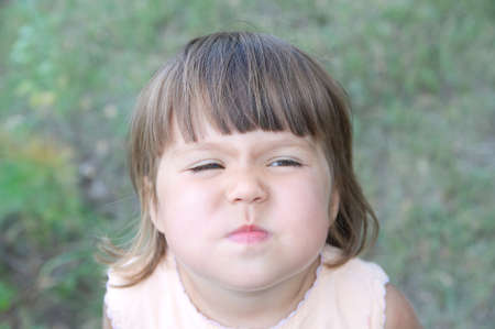 Little girl wrinkle nose making funny face portrait from aboveの写真素材
