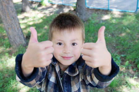 Kid show thumb up signat summer in parkの写真素材