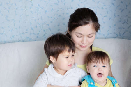 Happy mother with two daughters, multinational family with Asian mom and Caucasian little girlsの写真素材