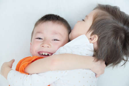 happy children, laughing kids hugging each other, closeup portrait of boy and little girl, happiness in childhood of siblingsの写真素材